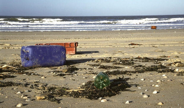 <p>Zwerfvuil op strand plastic krat en vat</p>