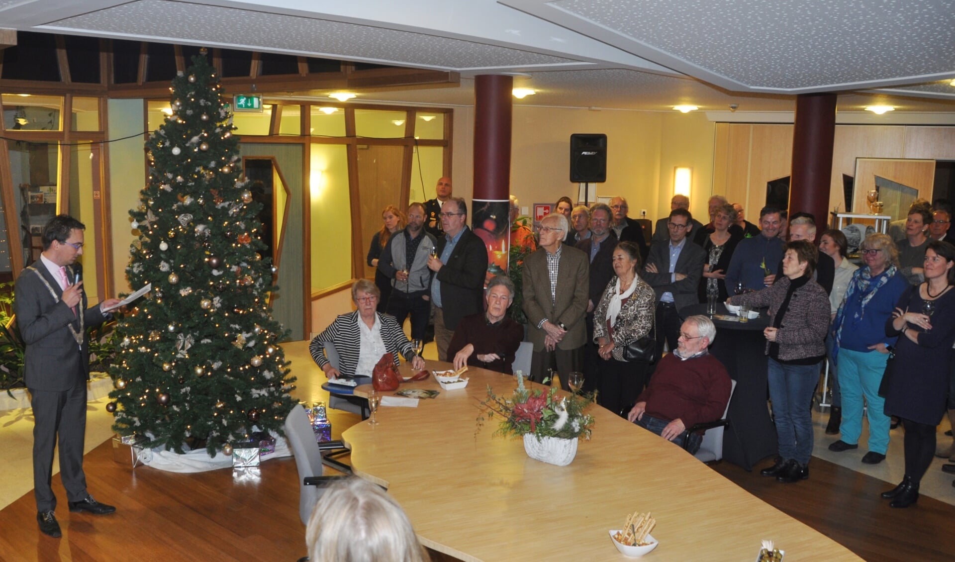 Bezoekers van de nieuwjaarsreceptie van de gemeente luisteren naar de toespraak van burgemeester Michiel Uitdehaag. 