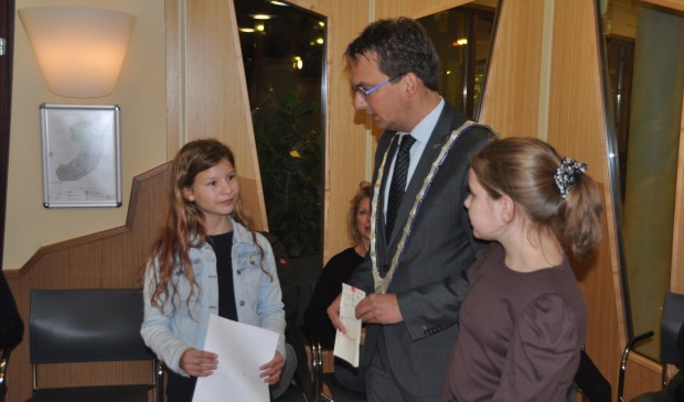 Bloem van der Velde en Rianne Witte overhandigen de handtekeningen aan burgemeester Uitdehaag.