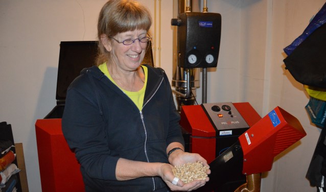 Jantien de Boer uit Oosterend met een hand brandstof voor de pelletketel. Zaterdagmiddag doet ze mee aan de Energieneutrale Huizenroute.
