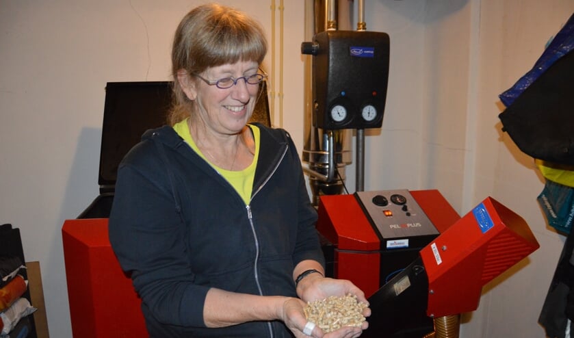 Jantien de Boer uit Oosterend met een hand brandstof voor de pelletketel. Zaterdagmiddag doet ze mee aan de Energieneutrale Huizenroute.