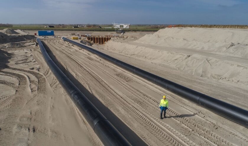 Hoogheemraad Kees Stam van Hollands Noorderkwartier bekijkt de nieuwe buizen tussen het PH-gemaal en de Waddenzee.