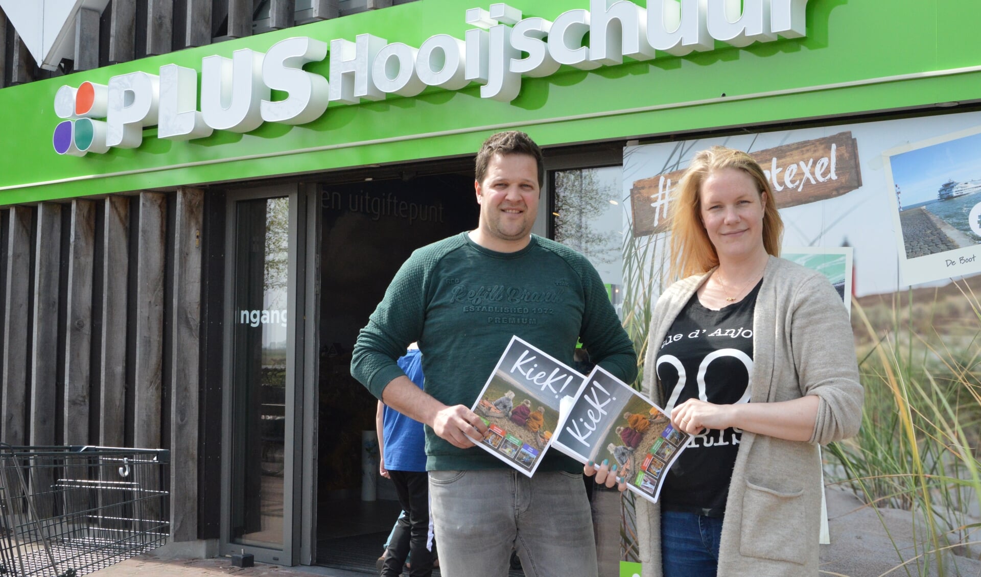 Erwin Goenga en  Lyanne Hooijschuur voor de nieuwe selfiespot voorop de winkel.