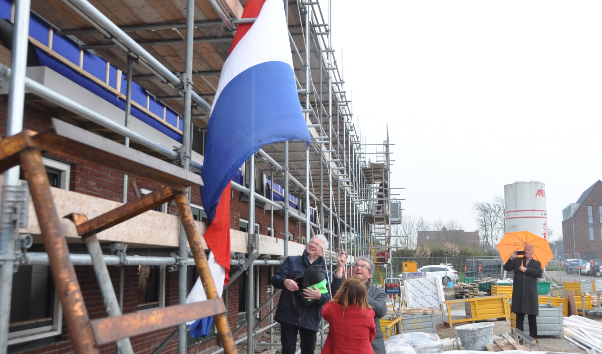 Wethouder Hennie Huisman en Jan van Andel hijsen de vlag.