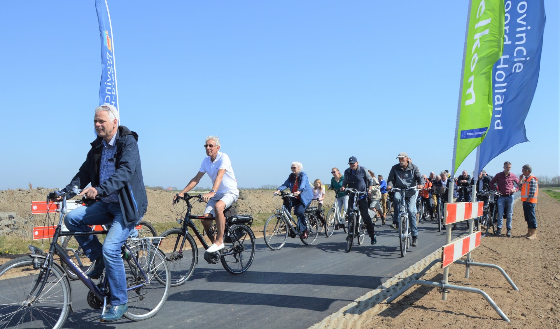 Op De Staart zijn de hekken aan de kant, fietsers openen de vernieuwde weg door Waalenburg. 