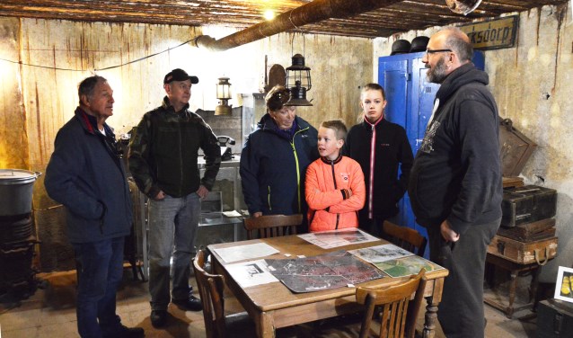 Vrijwilligers Pieter-Jan Kampstra (rechts) en Harry Kingma (tweede van links) geven bezoekers uitleg in de bunker.  