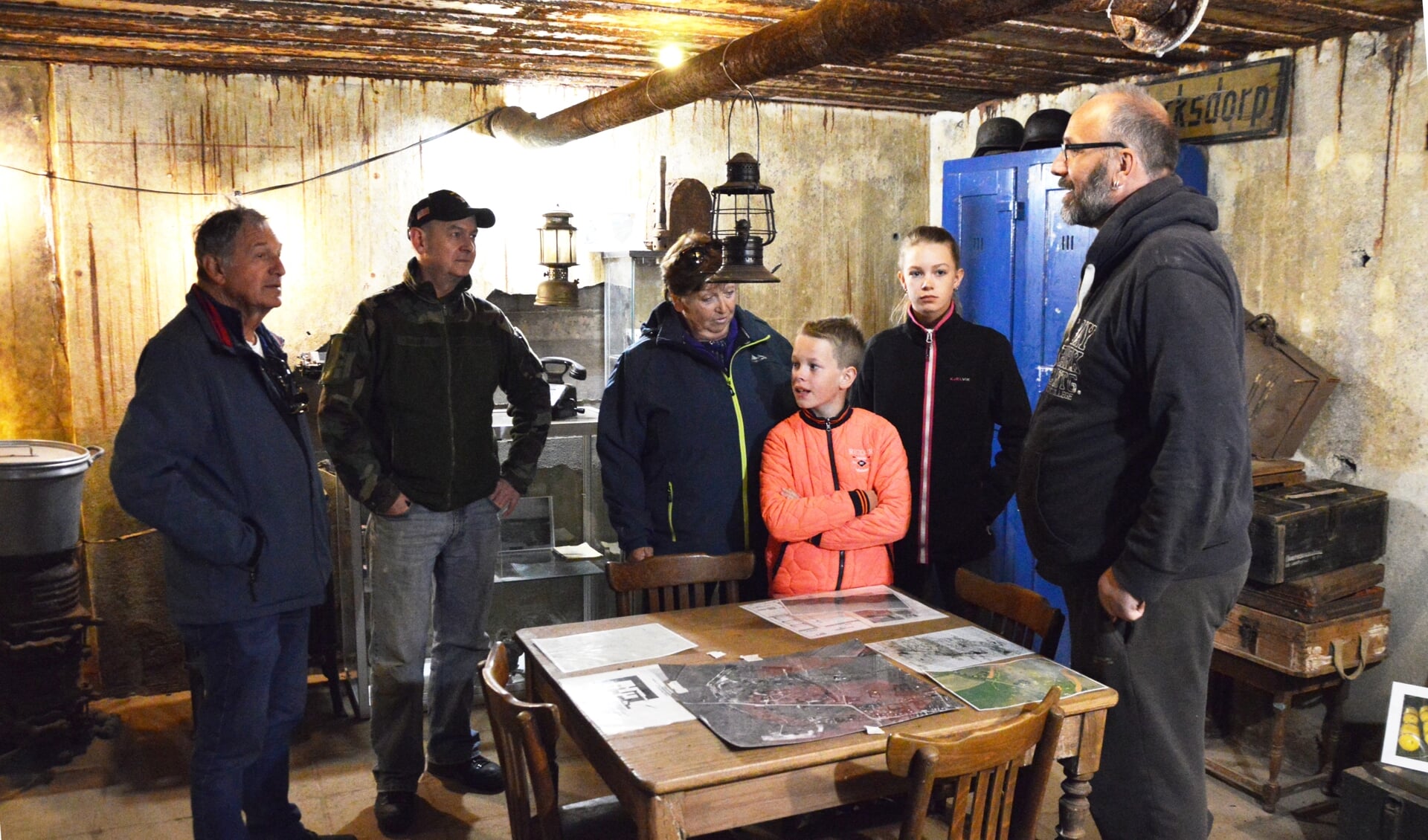 Vrijwilligers Pieter-Jan Kampstra (rechts) en Harry Kingma (tweede van links) geven bezoekers uitleg in de bunker. 