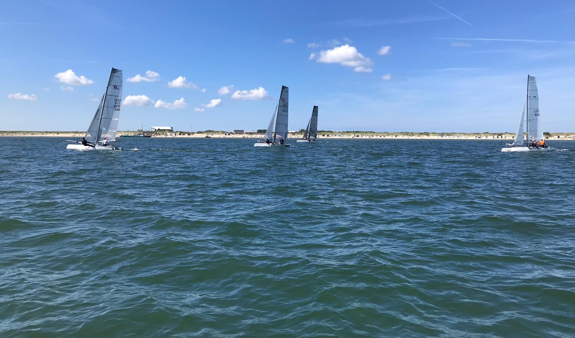 Catamarans passeren de kop van het eiland.