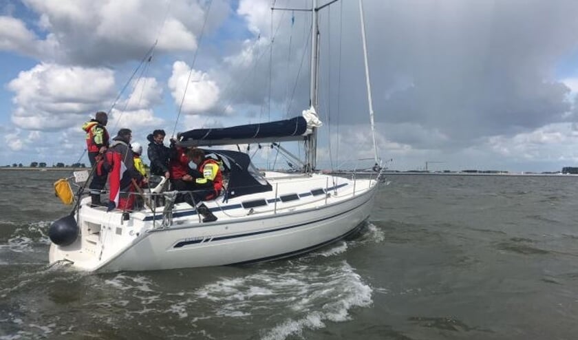 Het zeiljacht met redders van de KNRM aan boord.