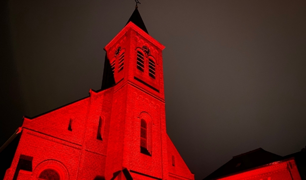 <p>De Johannes de Doper kerk in Den Burg toen die in 2020 rood verlicht was.</p>