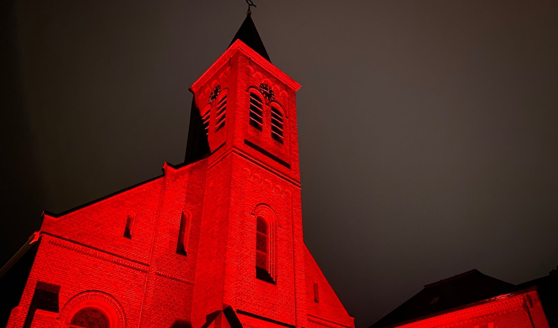 De Johannes de Doper kerk in Den Burg toen die in 2020 rood verlicht was.