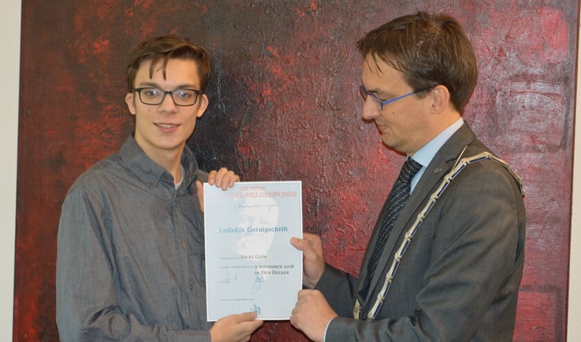 Burgemeester Uitdehaag overhandigt het getuigschrift van het Carnegie Heldenfonds aan Nigel Tervoort.