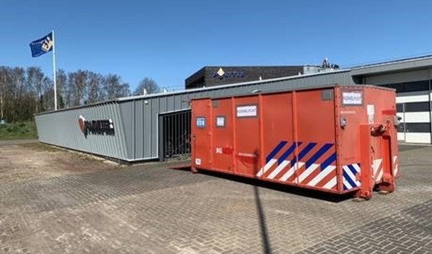 De rode bak waar de beschermingsmiddelen ingedaan kunnen worden.