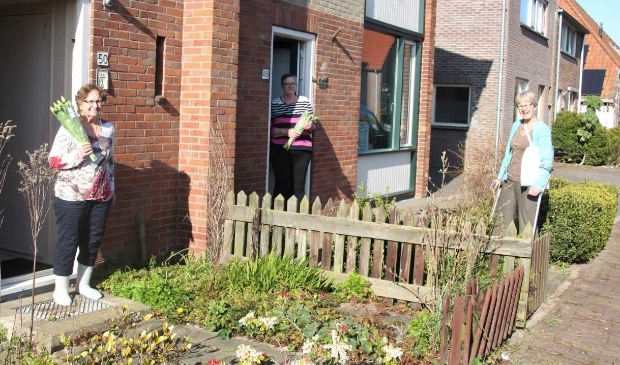 Corrie de Jager van de dorpscommissie van De Waal verrast bewoners met een bos bloemen.