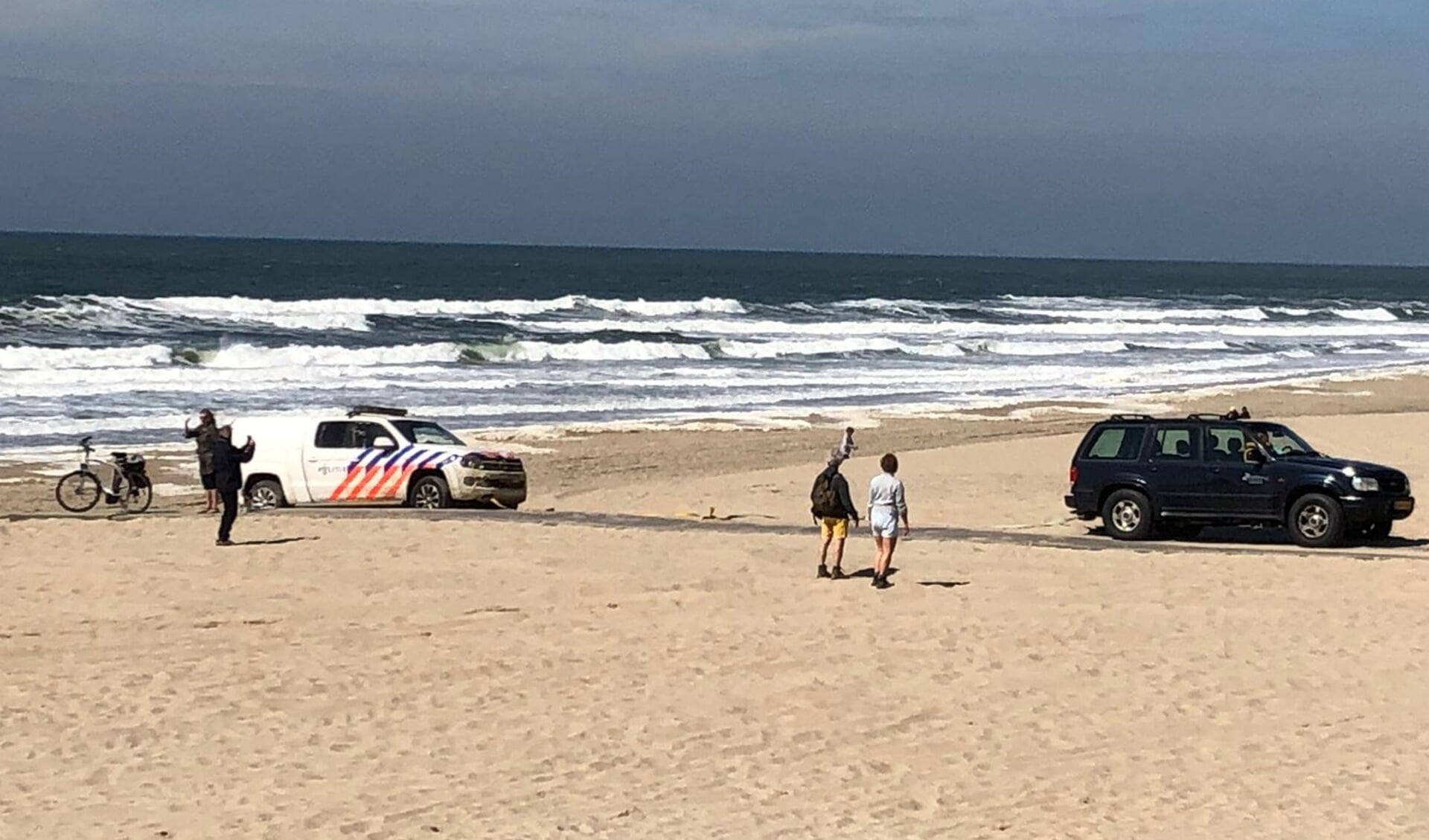 De politiewagen op het strand bij Paal 17.