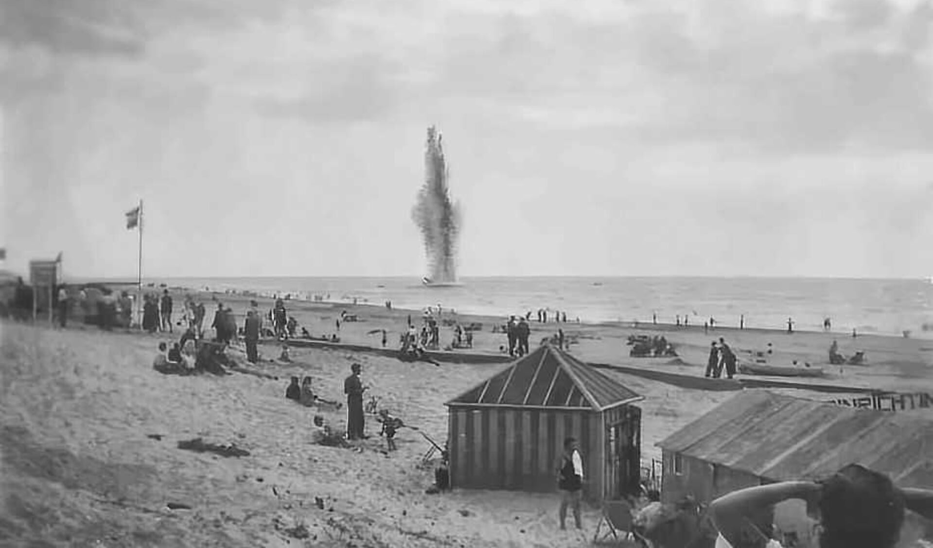 Badgasten zien vanaf het strand hoe een Kathymijn uit de oorlog voor de kust tot ontploffing wordt gebracht. Het water kon wel 30 meter hoog opspatten. 