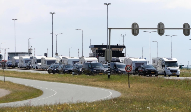 Verkeer dat van de boot komt, waaronder veel caravans en campers.