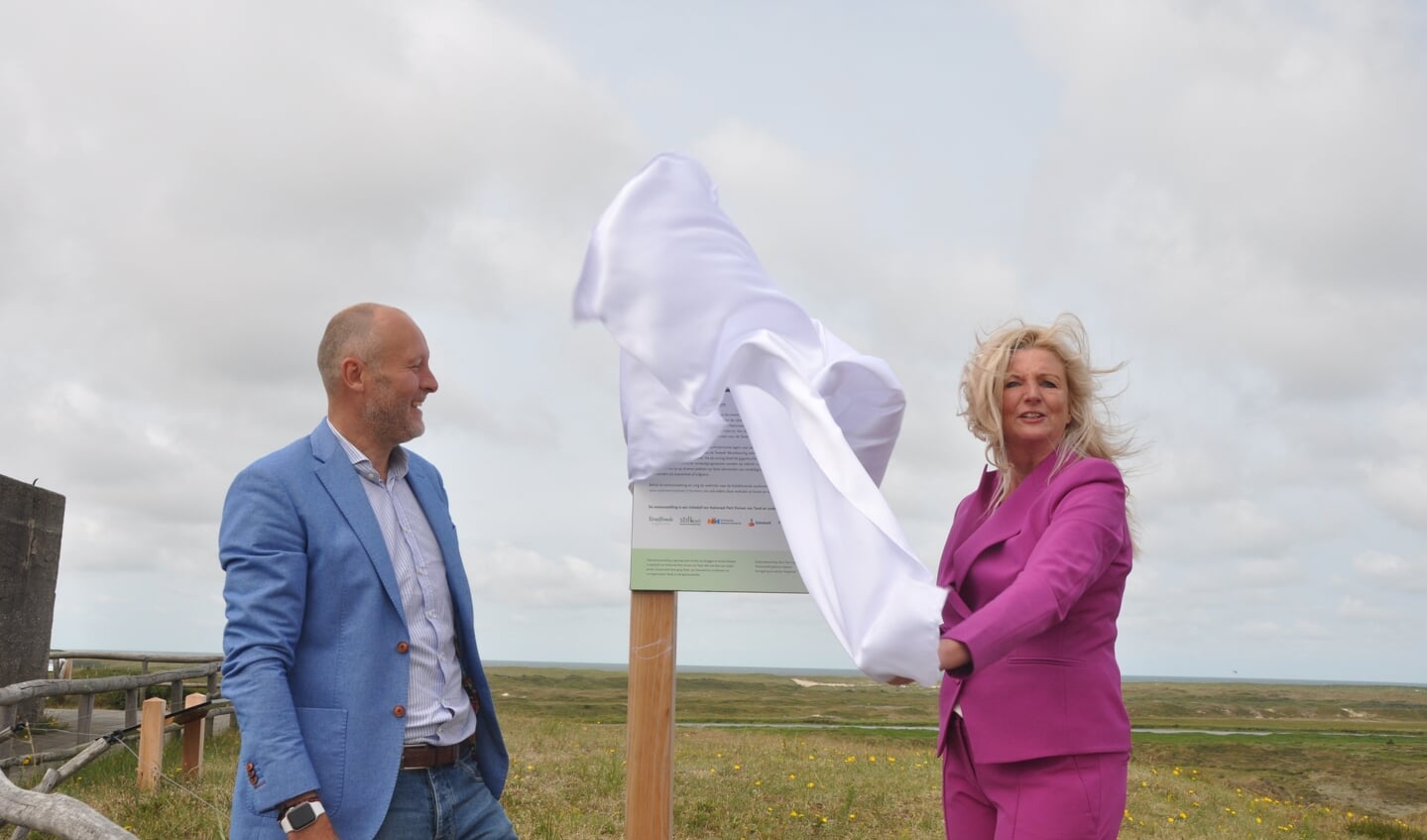 Gedeputeerde Esther Rommel onthult samen met Jan van der Venis een bord bij de toegang van de bunker van Loodsmansduin.