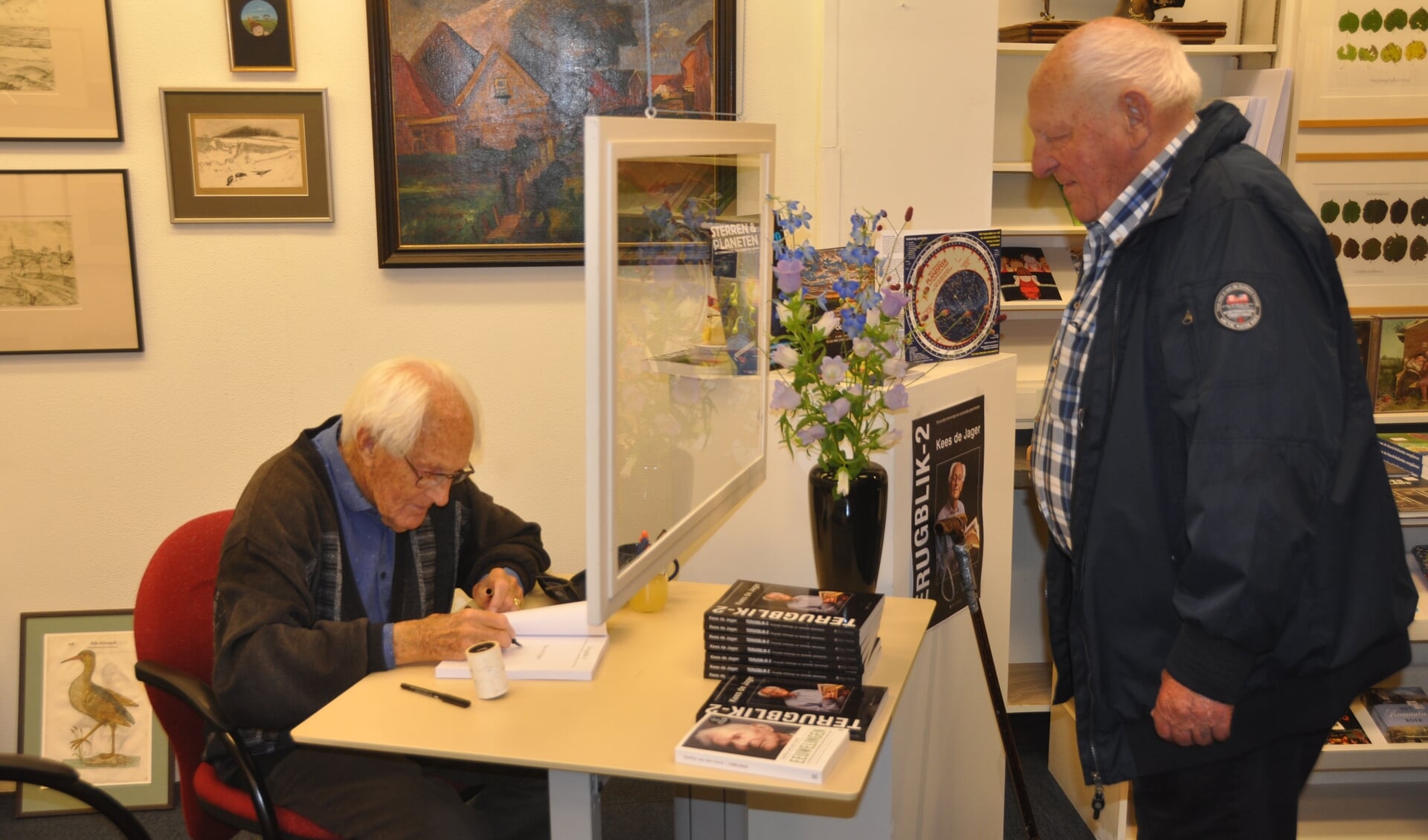 Professor Kees de Jager signeert voor Jan Geus.