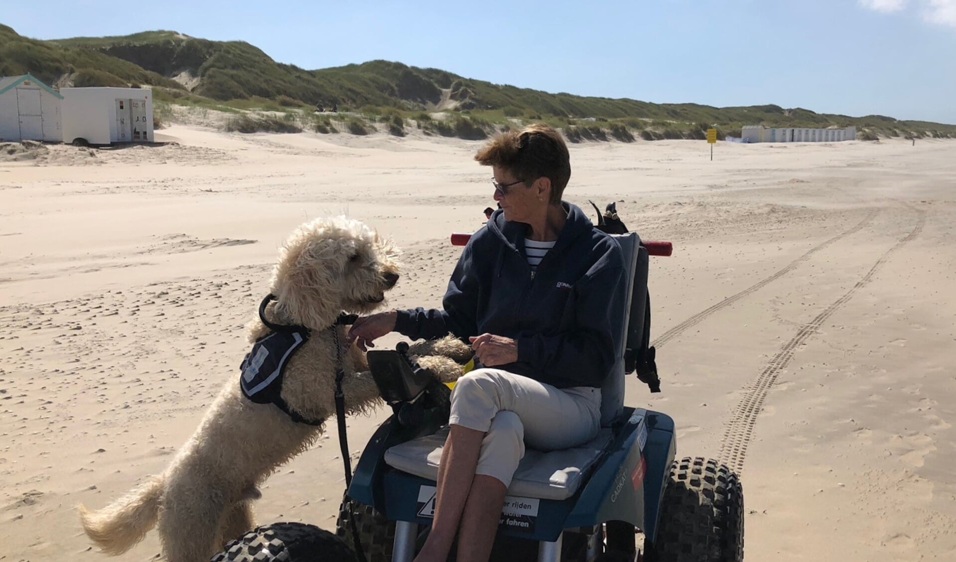 Erna Aarsen met hulphond Kaiko op het Texelse strand.