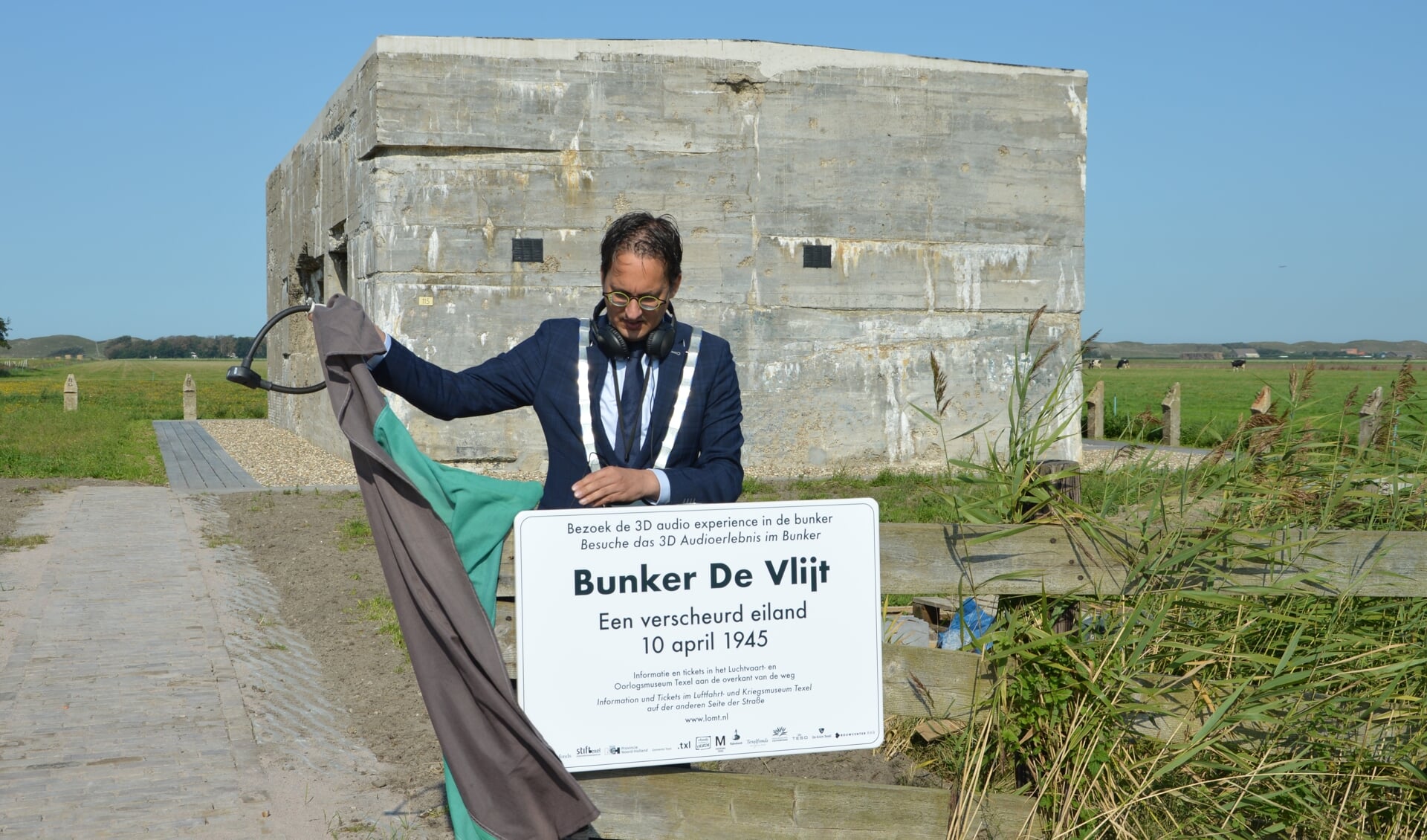 Burgemeester Uitdehaag onthult het bord bij bunker De Vlijt. 