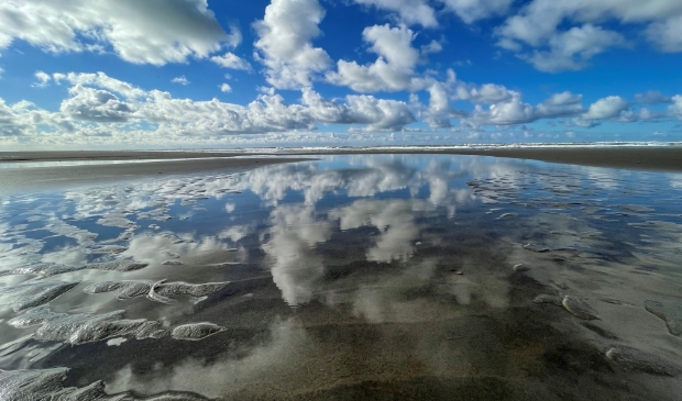 <p>Spiegeling van de wolken op het strand.</p>
