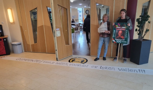 <p>Pieternel Geurz en Sjakkeliene Klaassen protesteren tijdens een raadsinformatiebijeenkomst. </p>