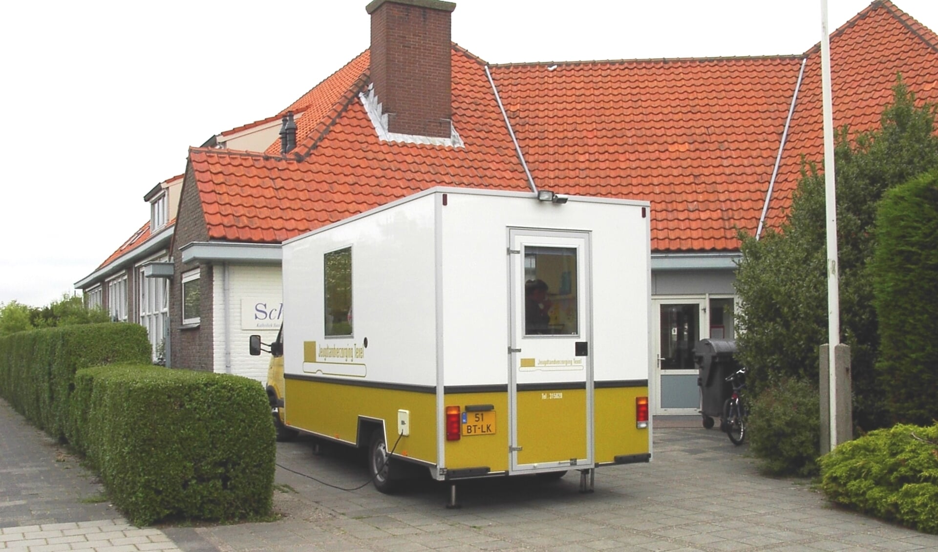 De dental car van de Stichting Jeugdtandverzorging bij de Jozefschool in Den Burg.