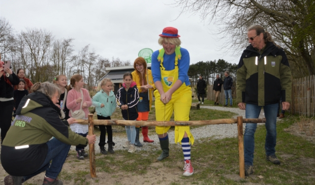 <p>Joris Jutter zaagt, geholpen door kinderen en Siem van Tatenhove en Conradine Reus van Natuur Goed Texel, de versperring tot het Blote Voetenpad door. </p>