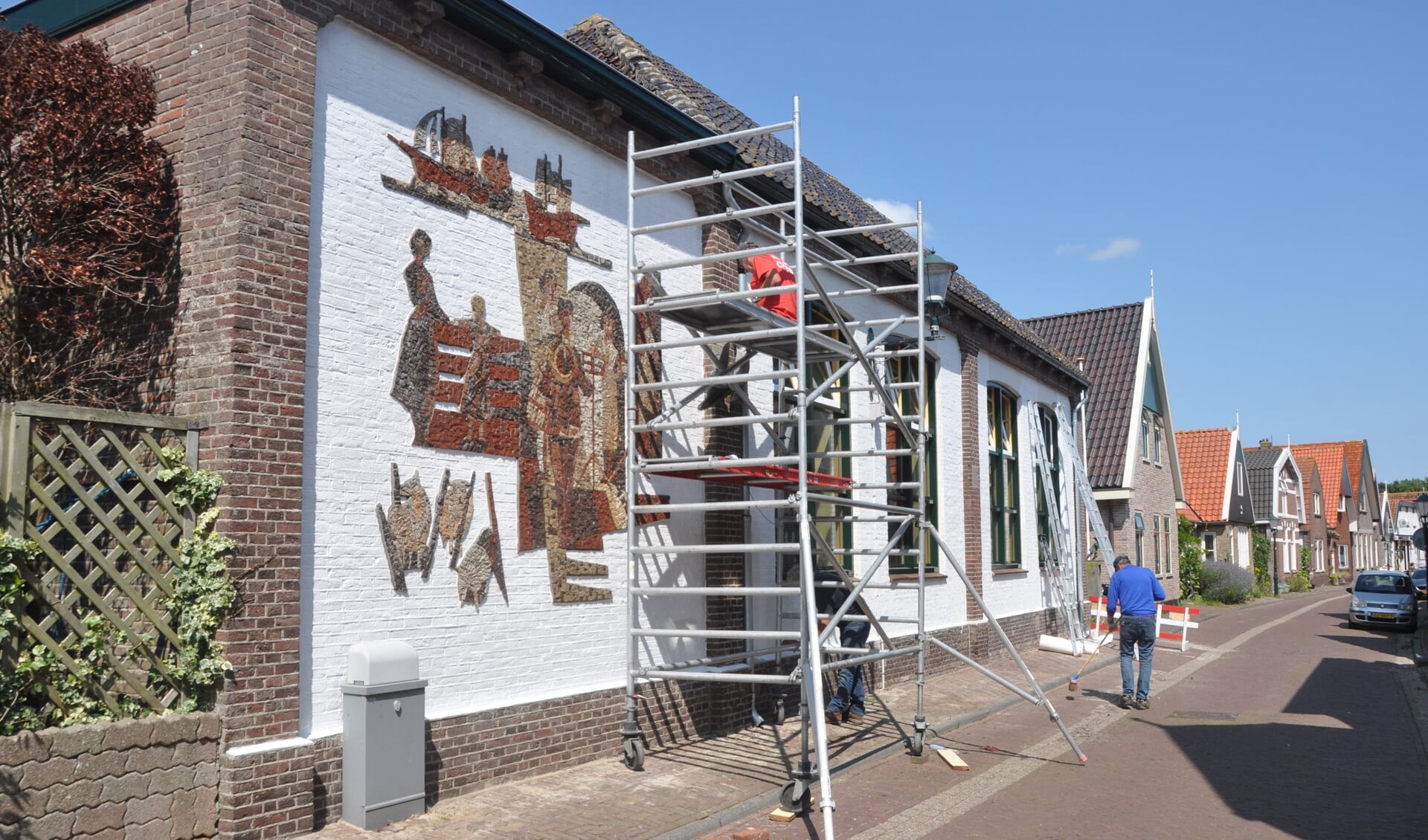 Het schilderen van het dorpshuis van Den Hoorn.