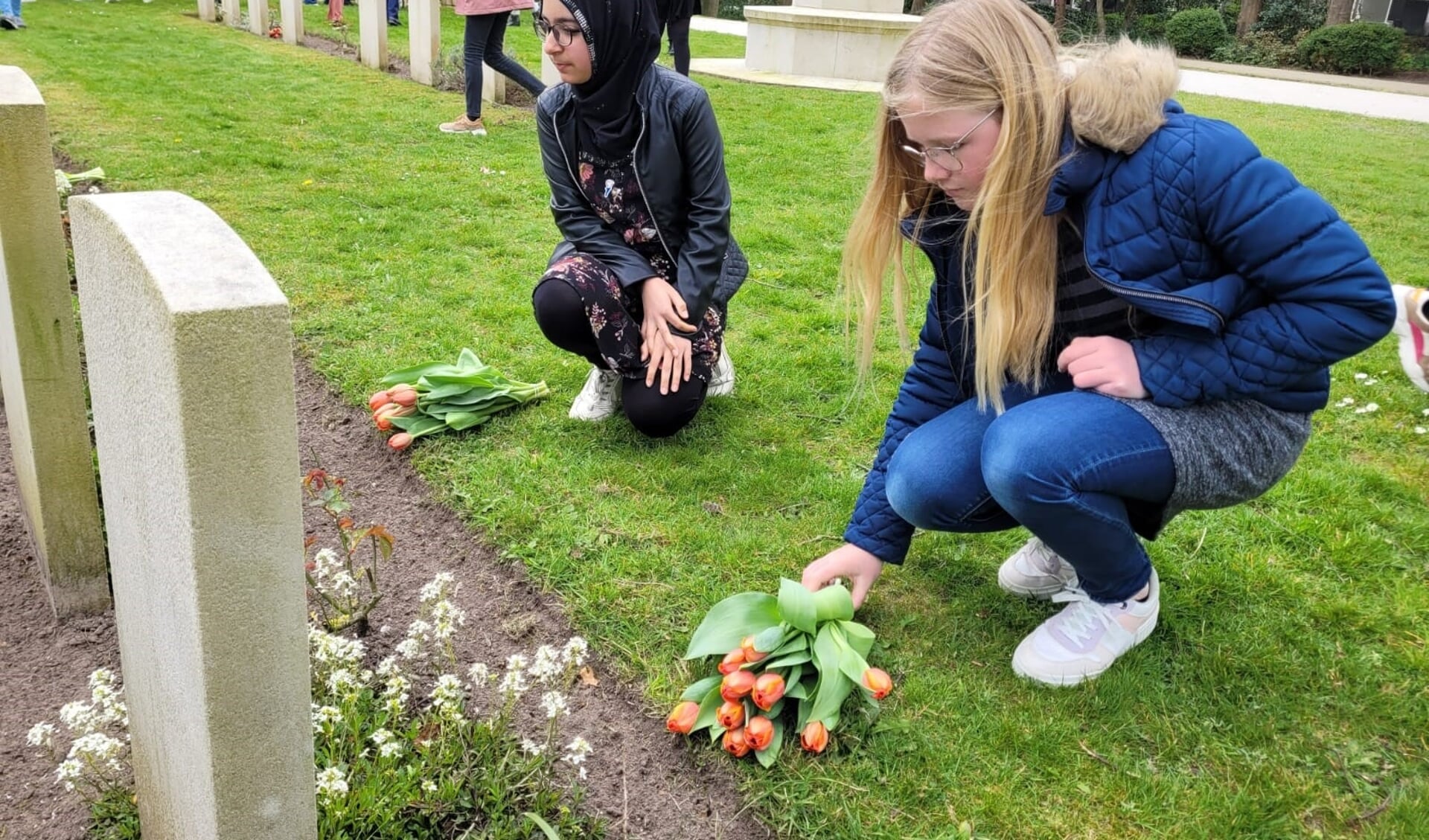 Leerlingen leggen bloemen bij de oorlogsgraven