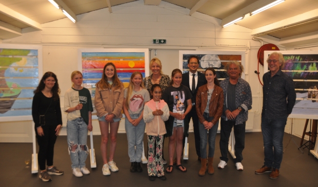 <p>De kinderen bij de kunstwerken die ze de afgelopen tijd onder leiding van Marleen Bakker van Artex maakten.</p>