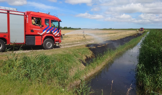 Bestrijding van de brand langs de sloot nabij de Oorsprongweg. 