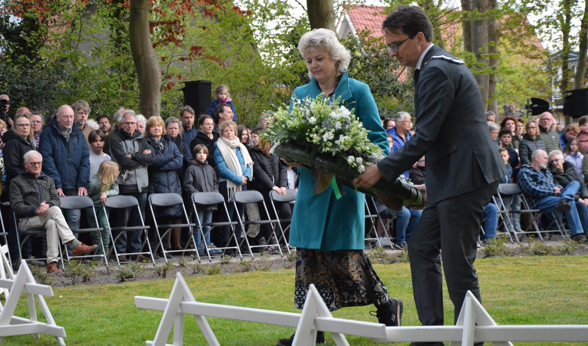 Cintha Stiekema en burgemeester Michiel Uitdehaag leggen een krans. 