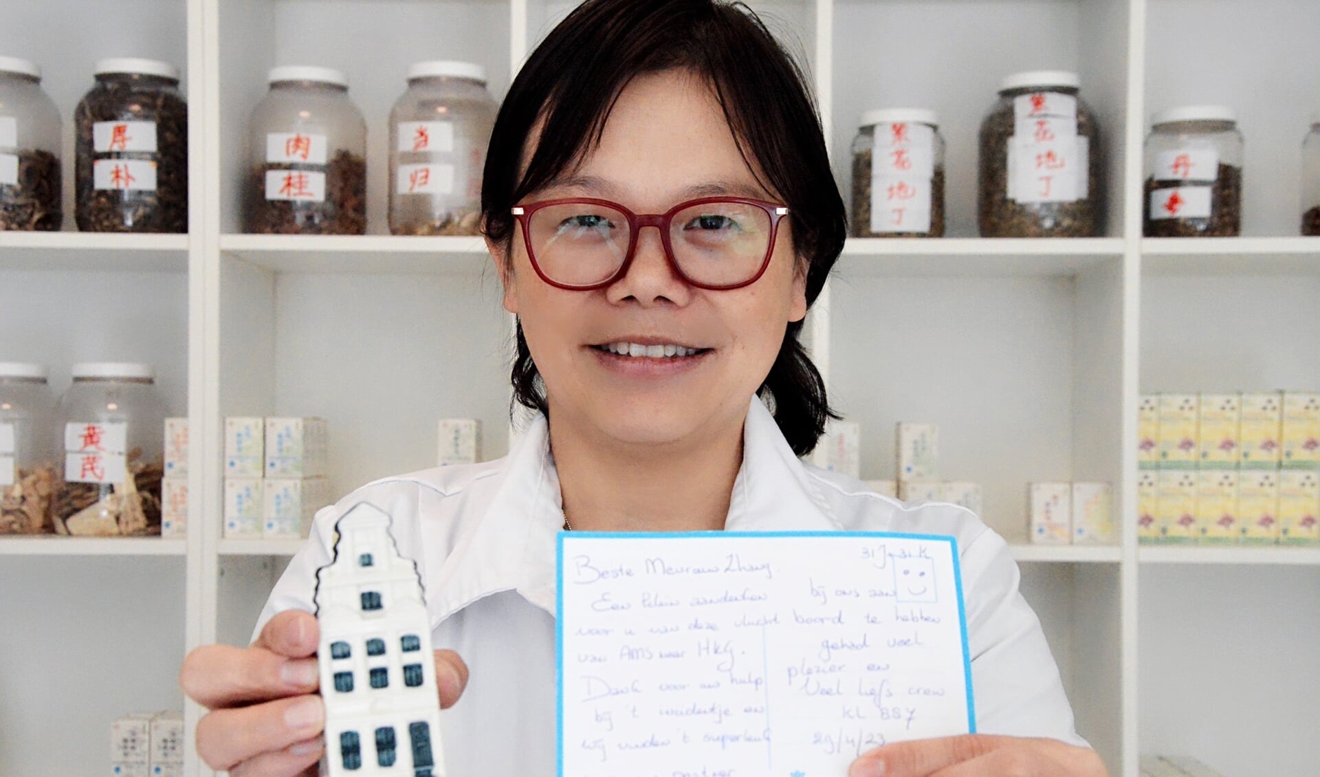 Ling Zhang met een kaart en een KLM-huisje, als dank voor haar medische hulp tijdens een vlucht. 
