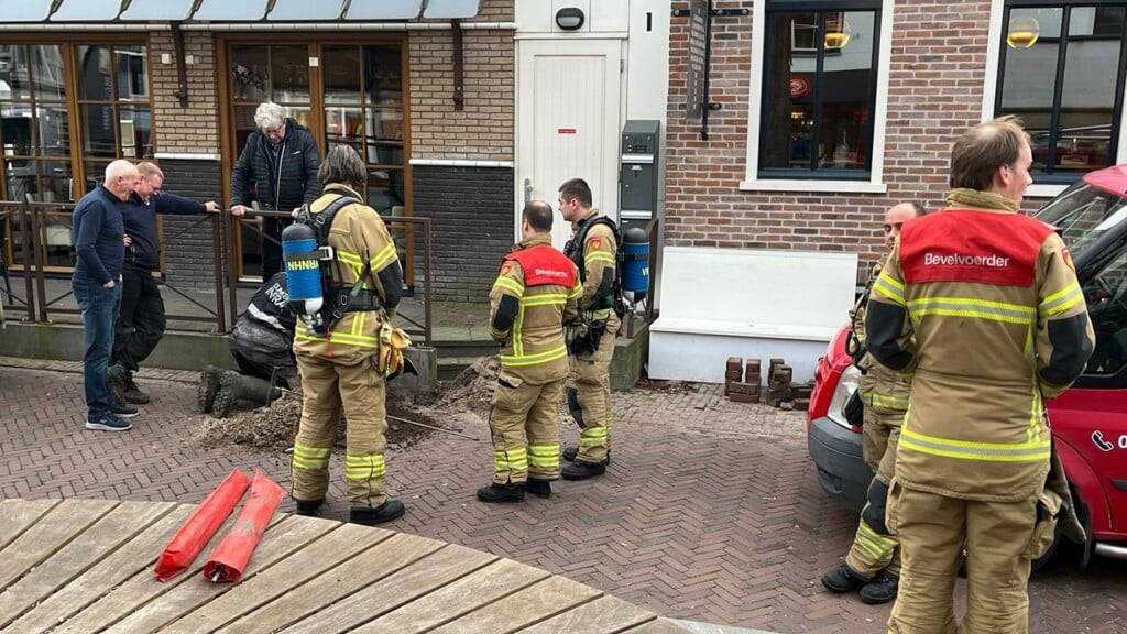 De brandweer in actie voor de gaslekkage in het centrum van Den Burg.