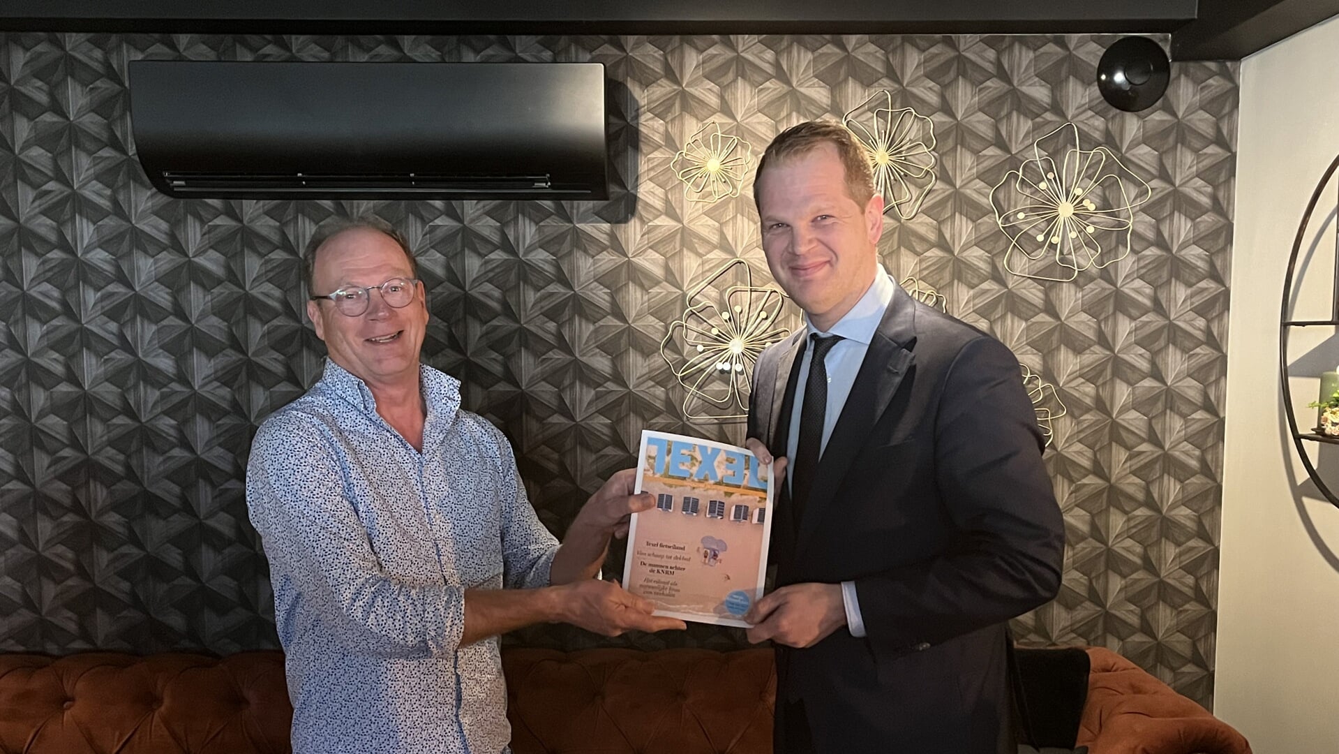 Burgemeester Mark Pol ontvangt het eerste exemplaar van Texel magazine-hoofdredacteur Gerard Timmerman,