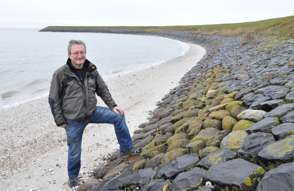 Jan Vonk, hier bij de museumdijk bij poldertje De Zandkes, gaat na 45 jaar dijkbeheer met pensioen. 'Hier zie je de historie', doelt hij onder meer op de verschillende soorten steen.