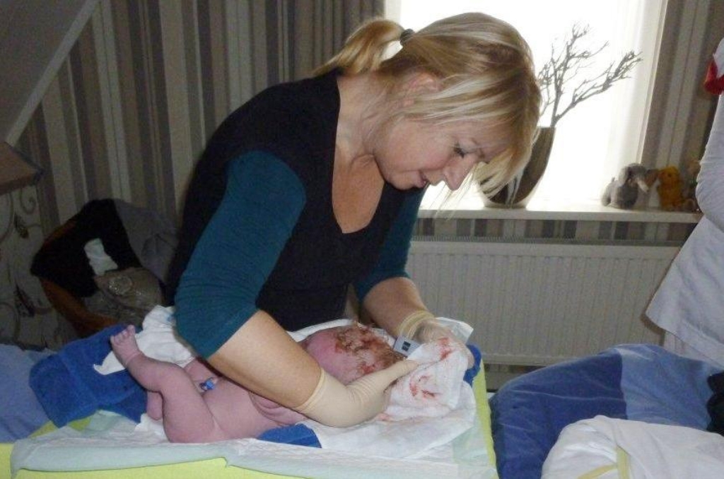 Petra Pop als verloskundige, met baby Koen, tien minuten na de geboorte. 