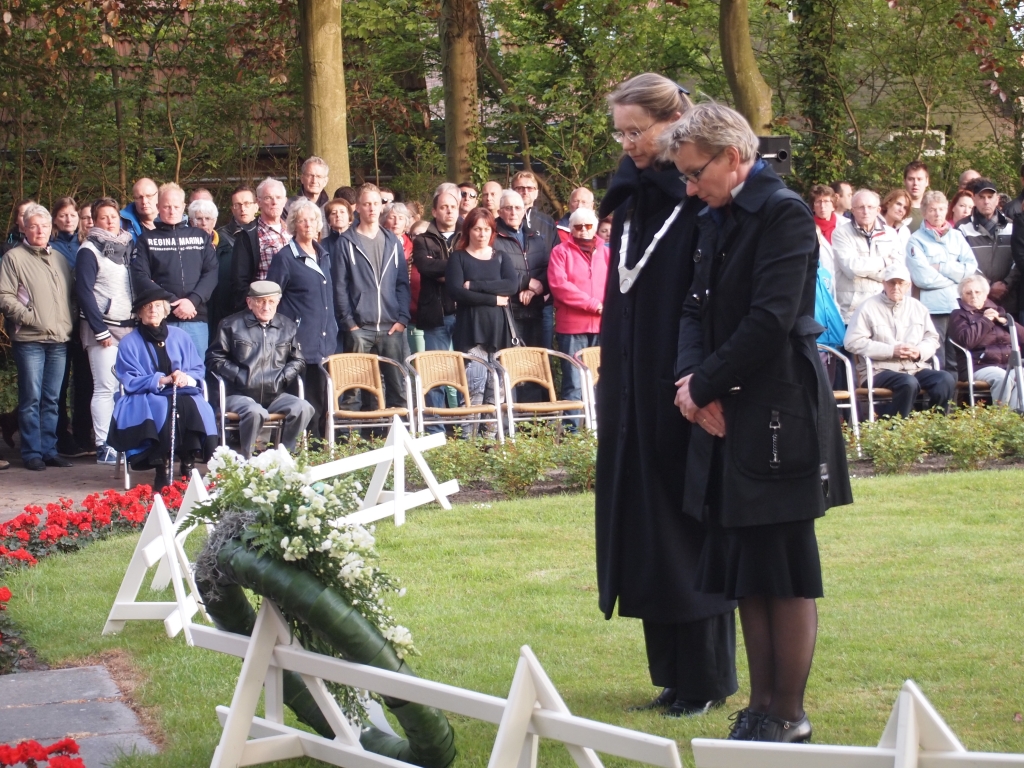 Burgemeester Giskes en theologe Ciska Stark leggen de eerste krans bij monument De Goede Herder.