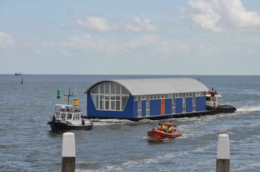 Begeleid door de Francine Kroesen wordt het nieuwe boothuis van de KNRM de haven van Oudeschild binnengevaren.