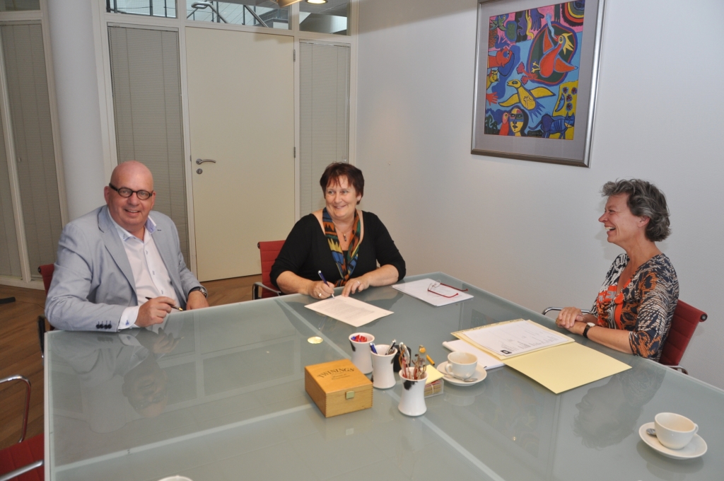 Bestuurders Ina Schrama en Peter van Gaalen tekenen de akte bij notaris Marjon Hoogerheide. 