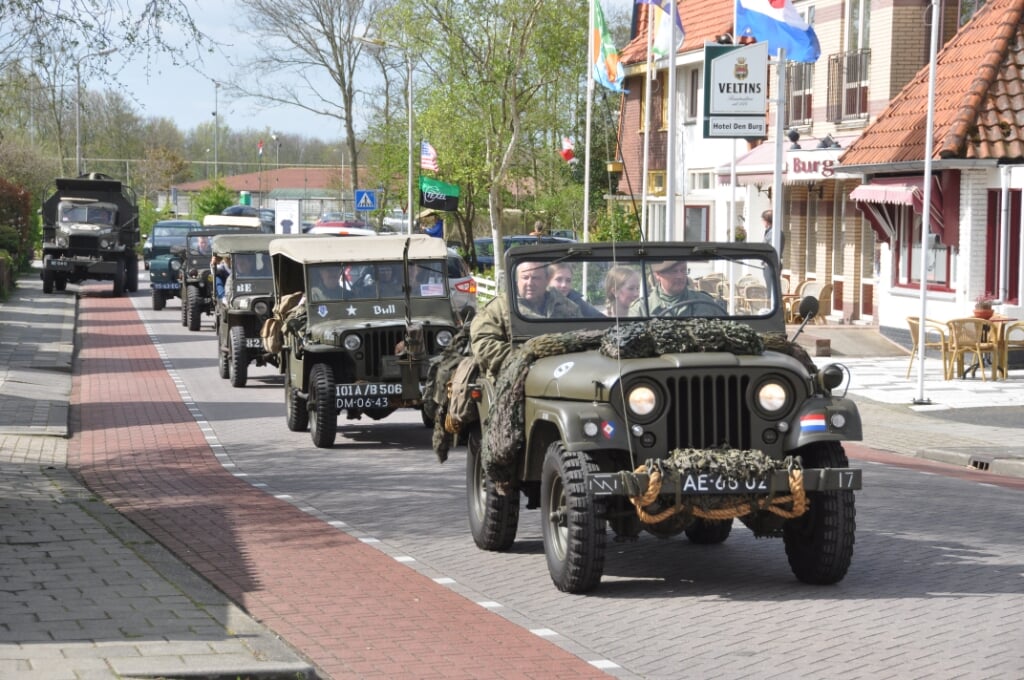 Een colonne legervoertuigen rijdt door Den Burg.