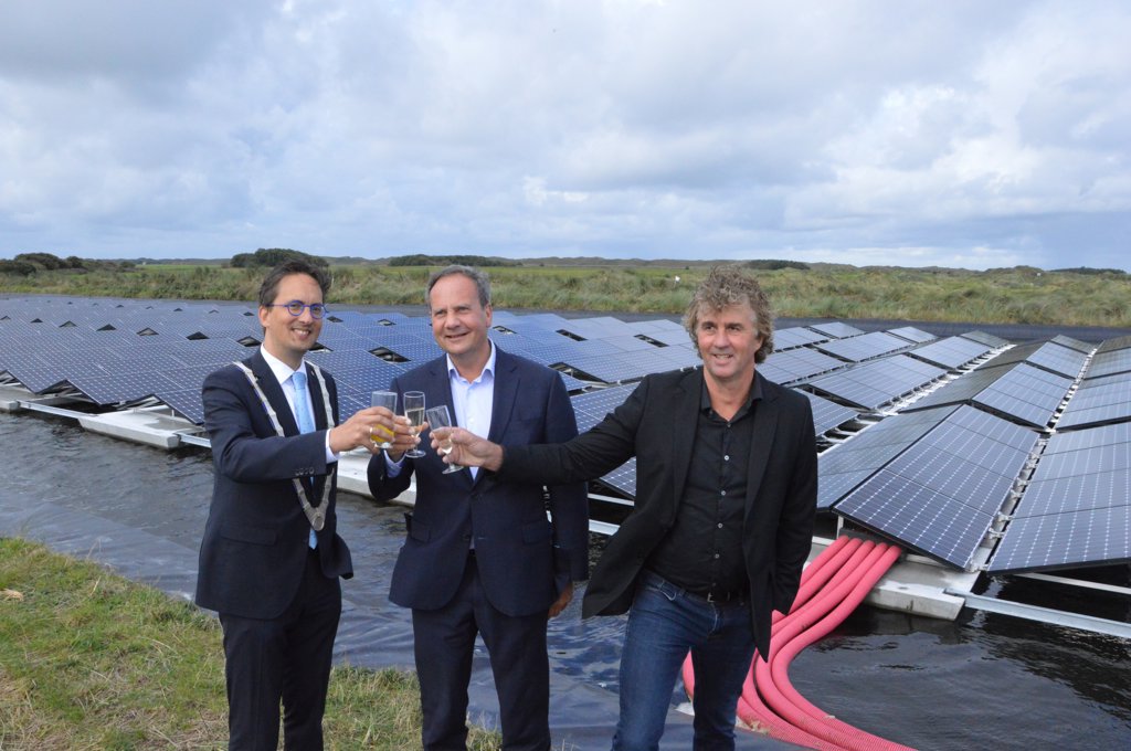 Burgemeester Michiel Uitdehaag, Iwan Groothuis en Nicol Schermer toosten op de zonnepanelen. 
