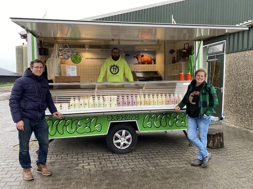 Evert Rikkenberg, Henk Pennings en Corine Rikkenberg van Zuivelboerderij Texel bij hun mobiele winkel "Zuivel onder de luifel". 