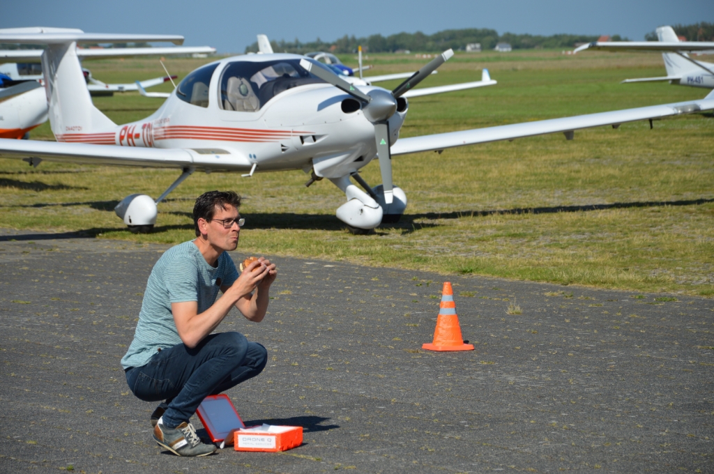 Mike de Bruijn van Texel Airport proeft het zojuist per drone bezorgde broodje hamburger. 