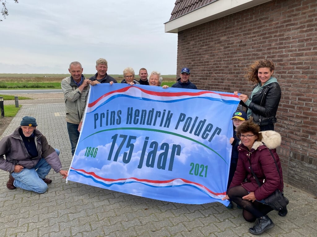 Bewoners van de 175-jarige Prins Hendrikpolder met de jubileumvlag.