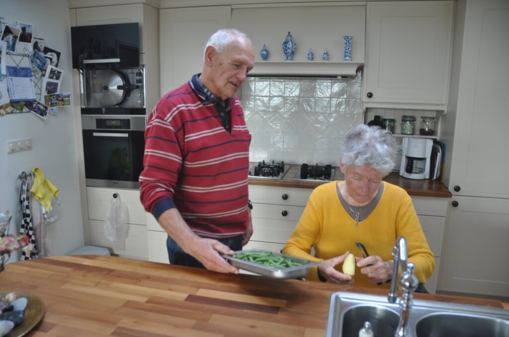 Hans en Miek Jimmink bereiden gezamenlijk de maaltijd in de keuken van hun huis.