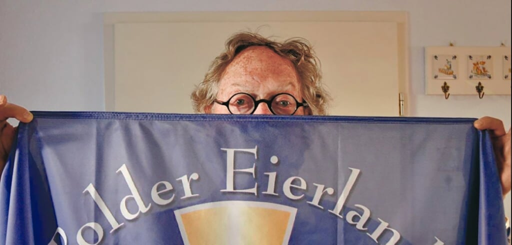 Jan Heemskerk in 2010 met de vlag van polder Eierland, waarvoor hij het jubileumboek schreef.