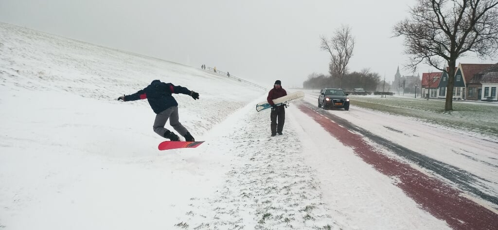 David Lodder en Daniël Bloem snowboarden van de dijk in Oudeschild. 